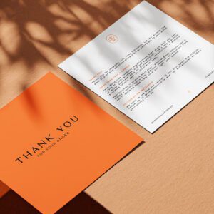 Two Tone Collection thank you cards on a textured background with natural light shadows one card in orange saying Thank You for Your Order and the other in white with additional text.