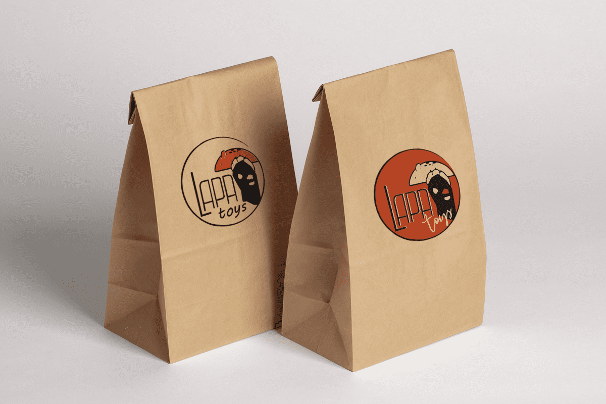 Two brown paper bags featuring the 'Lapa Toys' logo, with one bag showcasing an orange background and the other a neutral beige design.